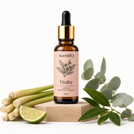 A 20ml amber glass dropper bottle of scentQ Vitality essential oil blend, styled on a wooden block with lemongrass, a lime wedge, and eucalyptus leaves against a white background.