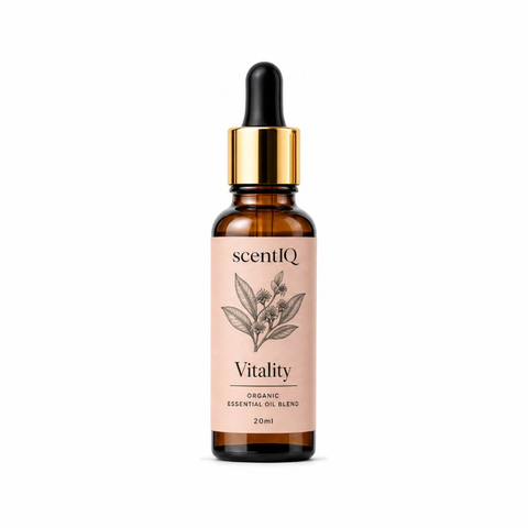 A 20ml amber glass dropper bottle of scentiQ Vitality Organic Essential Oil Blend, featuring a light pink label with a botanical illustration and a shiny gold collar with a black dropper cap, set against a plain white background.